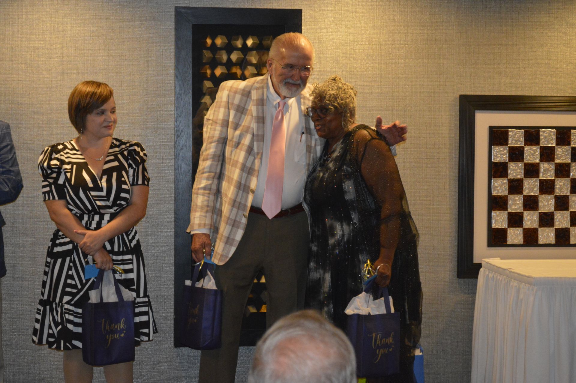 A man and woman are posing for a picture in front of a chess board.