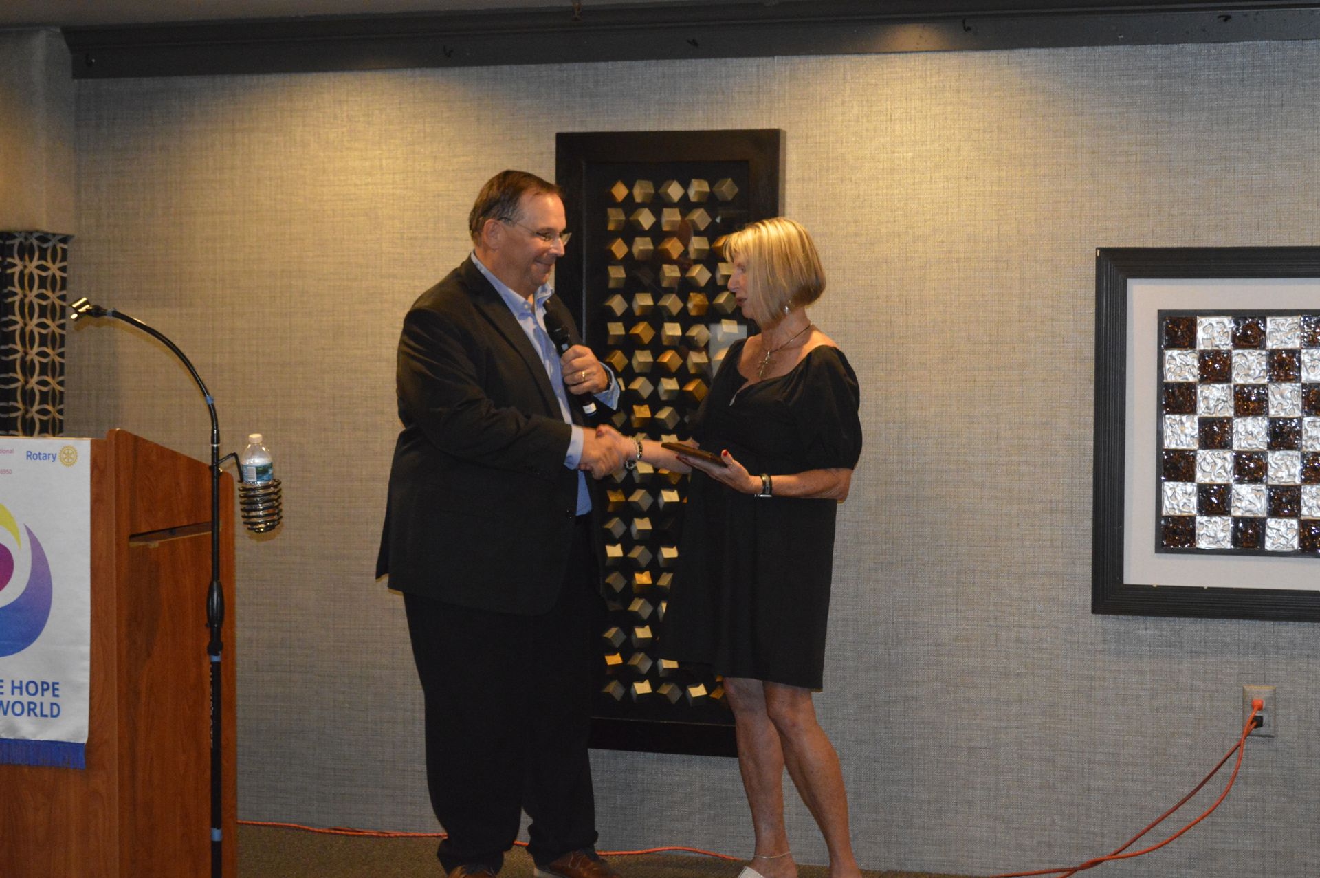 A man and a woman are standing next to each other in front of a chess board.