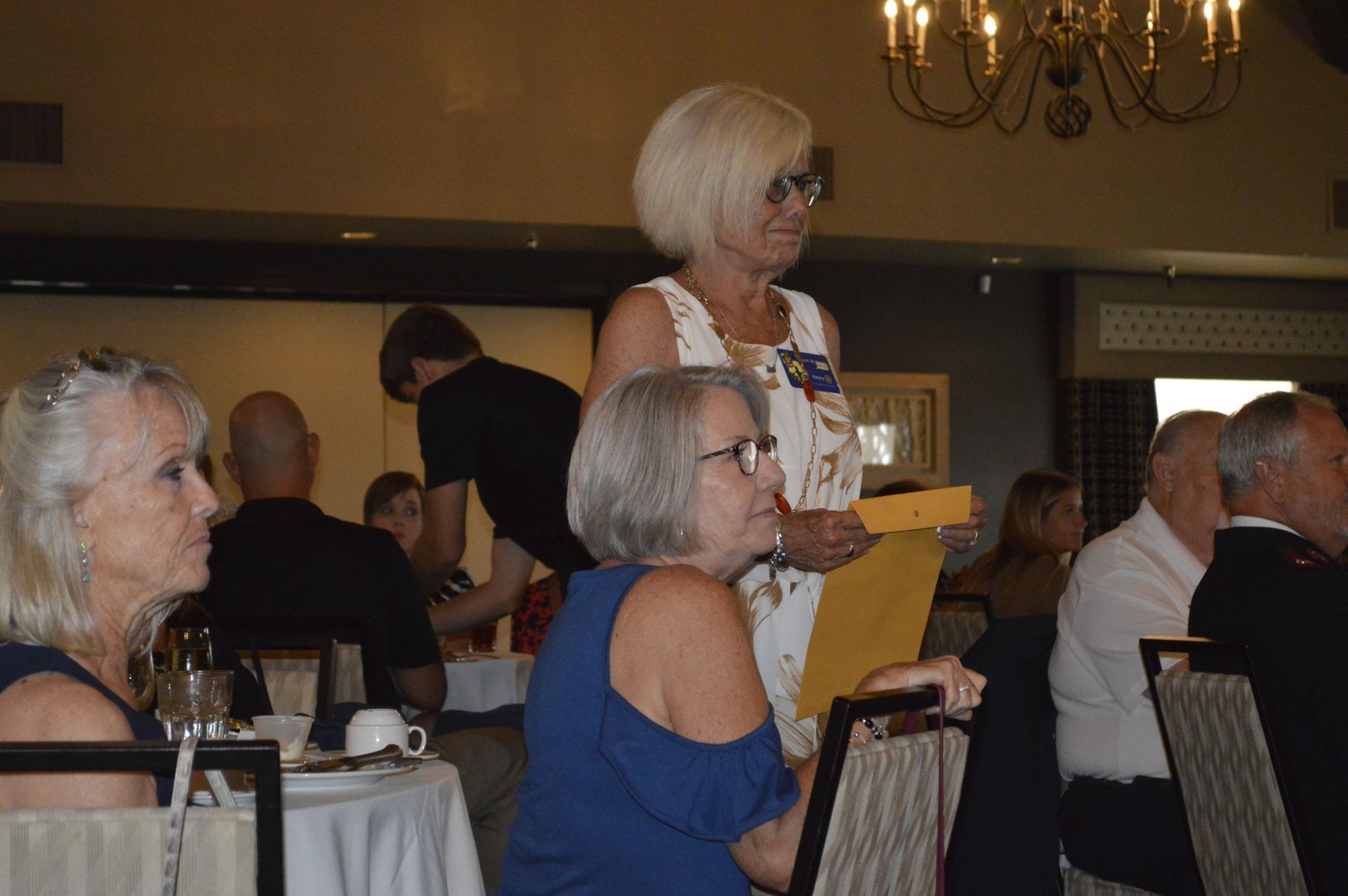 A group of people are sitting at tables in a restaurant.