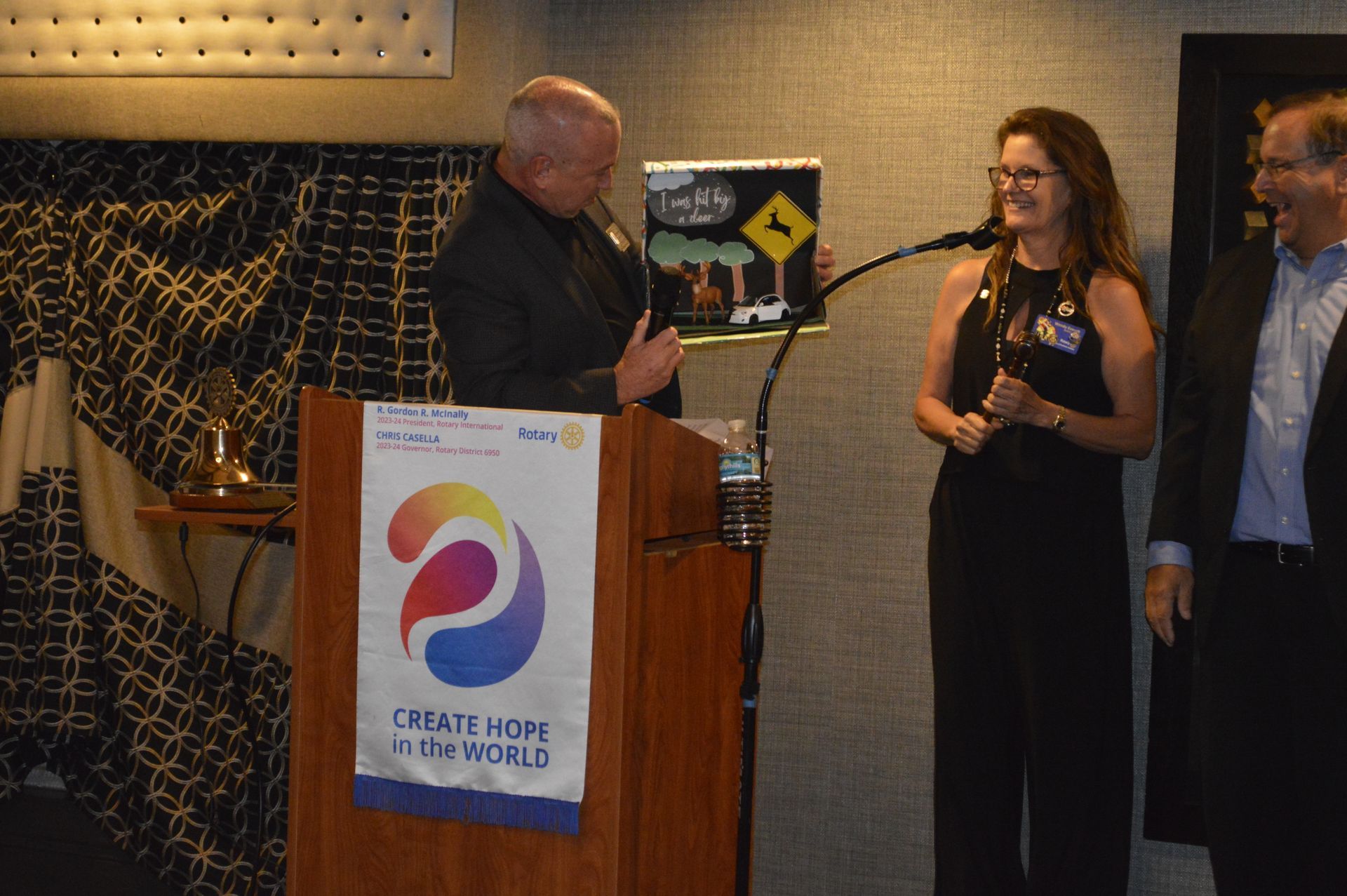 A man is giving a speech at a podium with a sign that says create hope in the world.