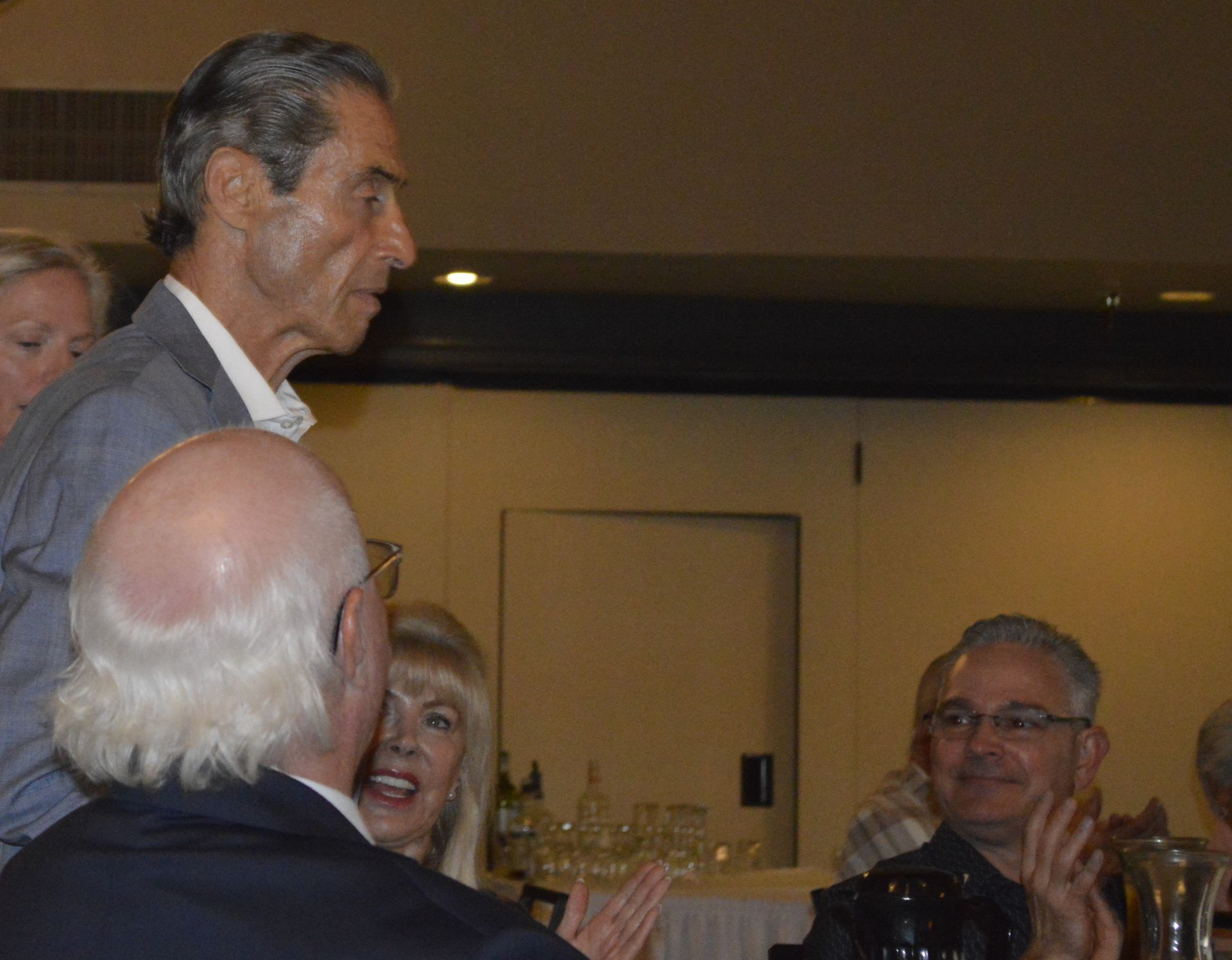A man in a suit is talking to a group of people