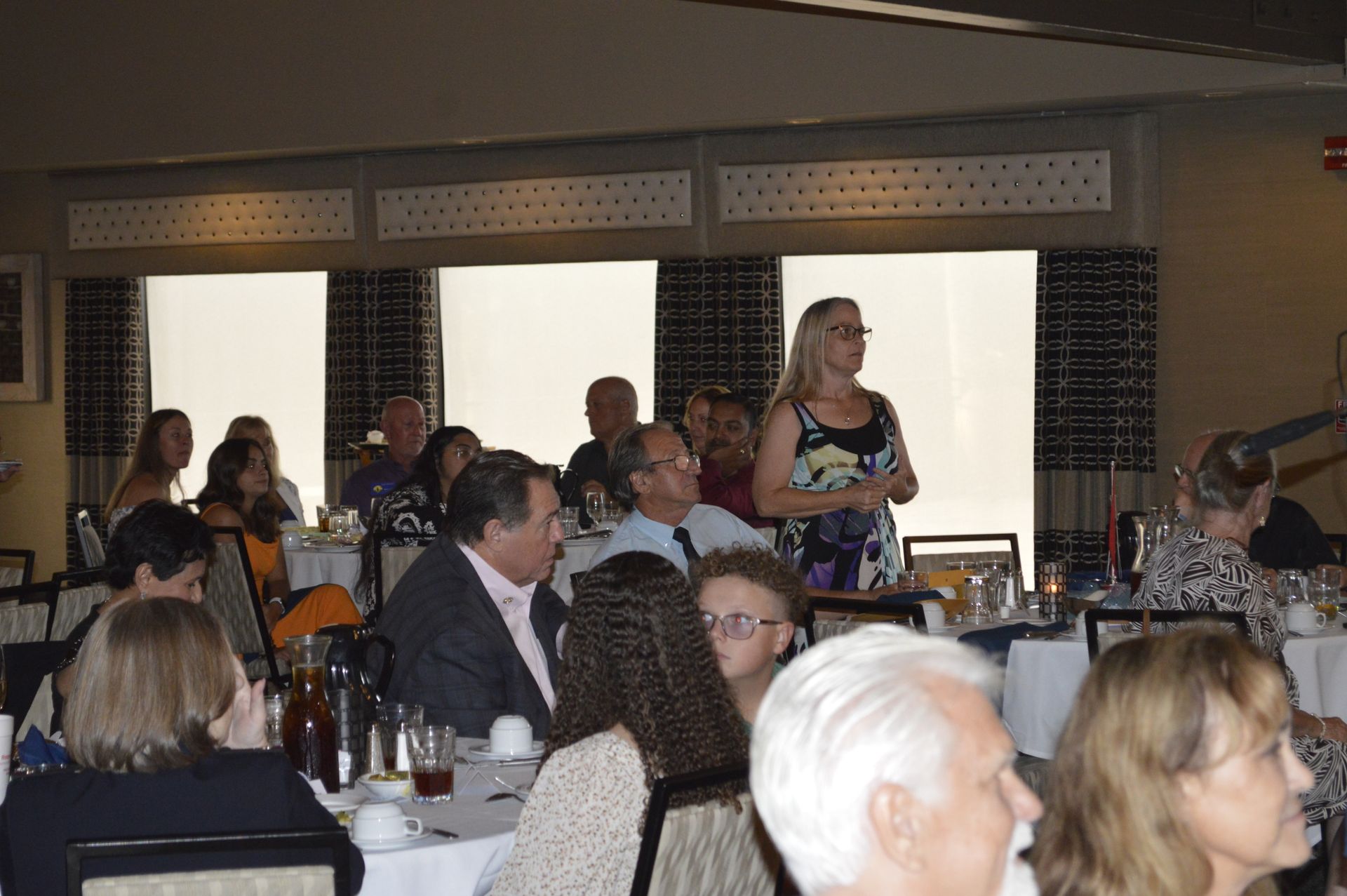 A group of people are sitting at tables in a restaurant.