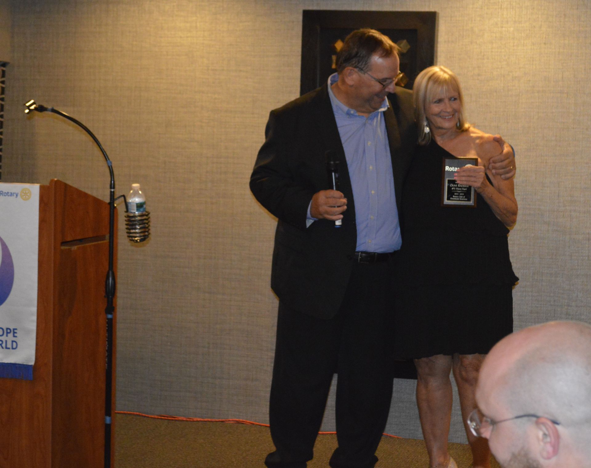 A man in a suit and a woman in a black dress are standing next to each other