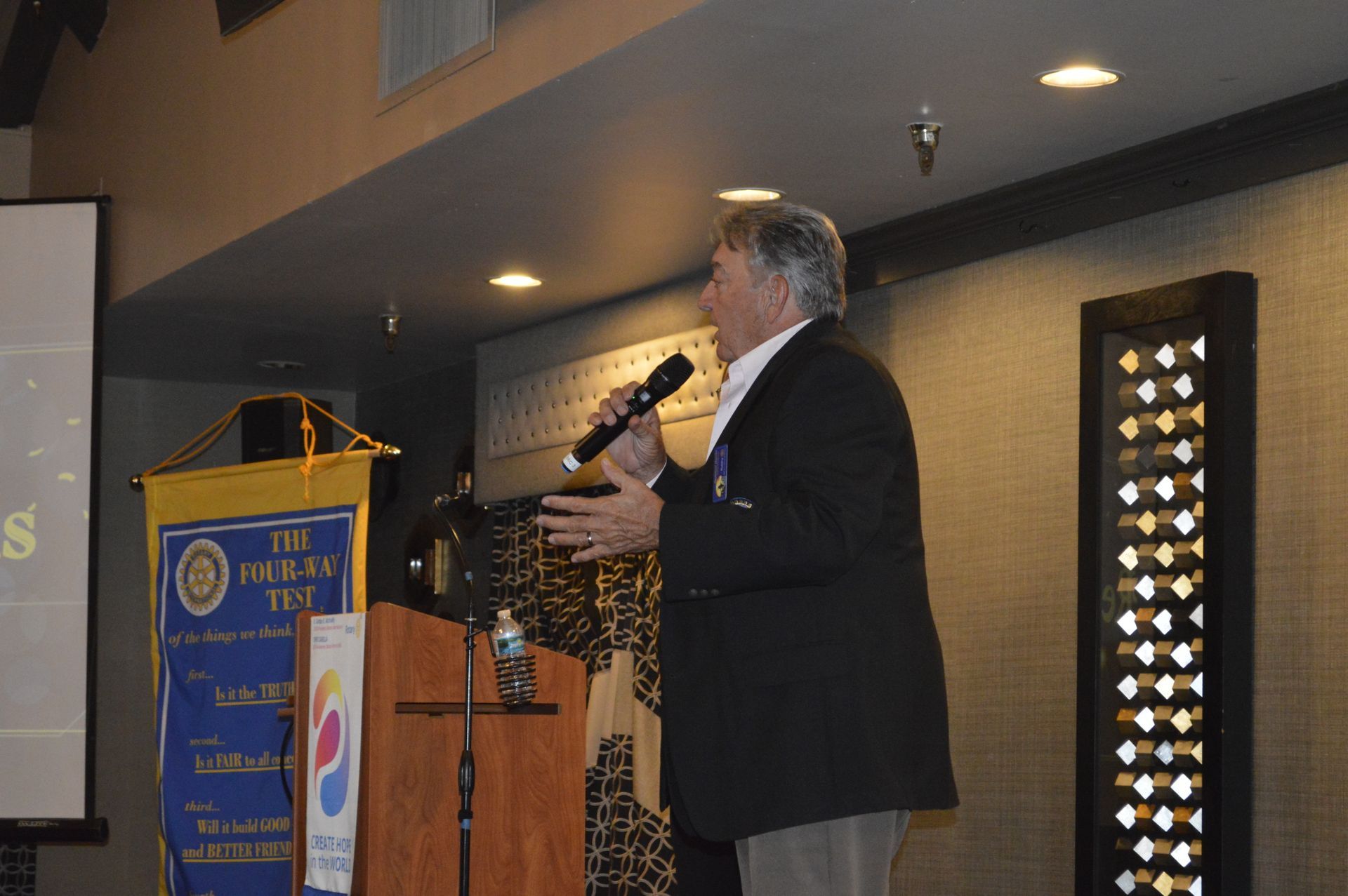 A man is standing at a podium holding a microphone
