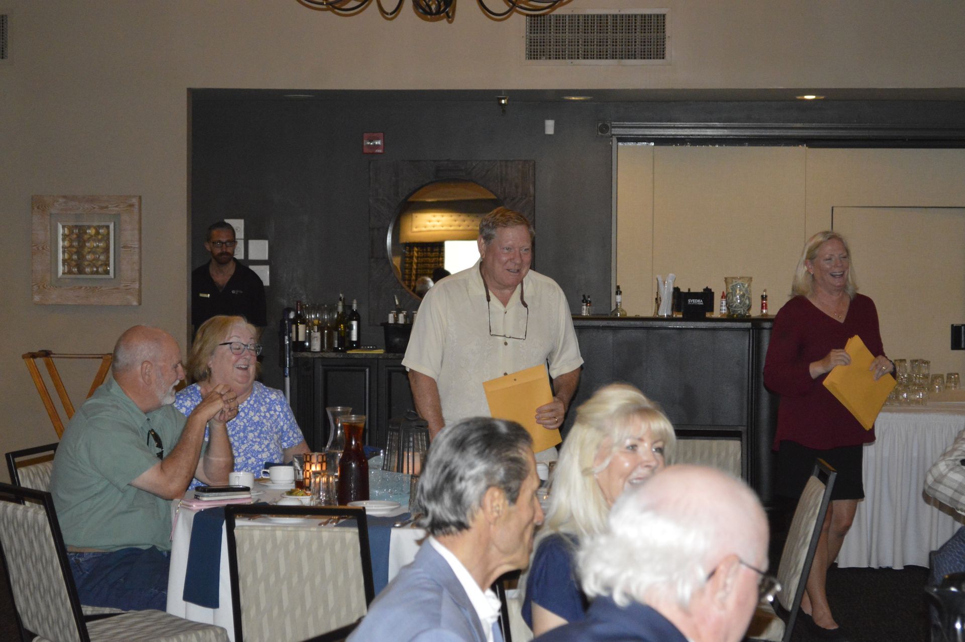 A group of people are sitting at tables in a restaurant.