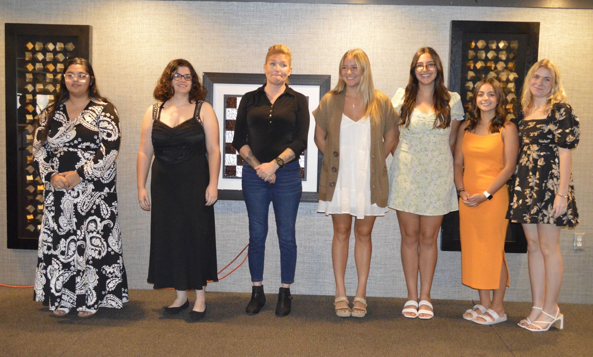 A group of women are standing next to each other in a room.