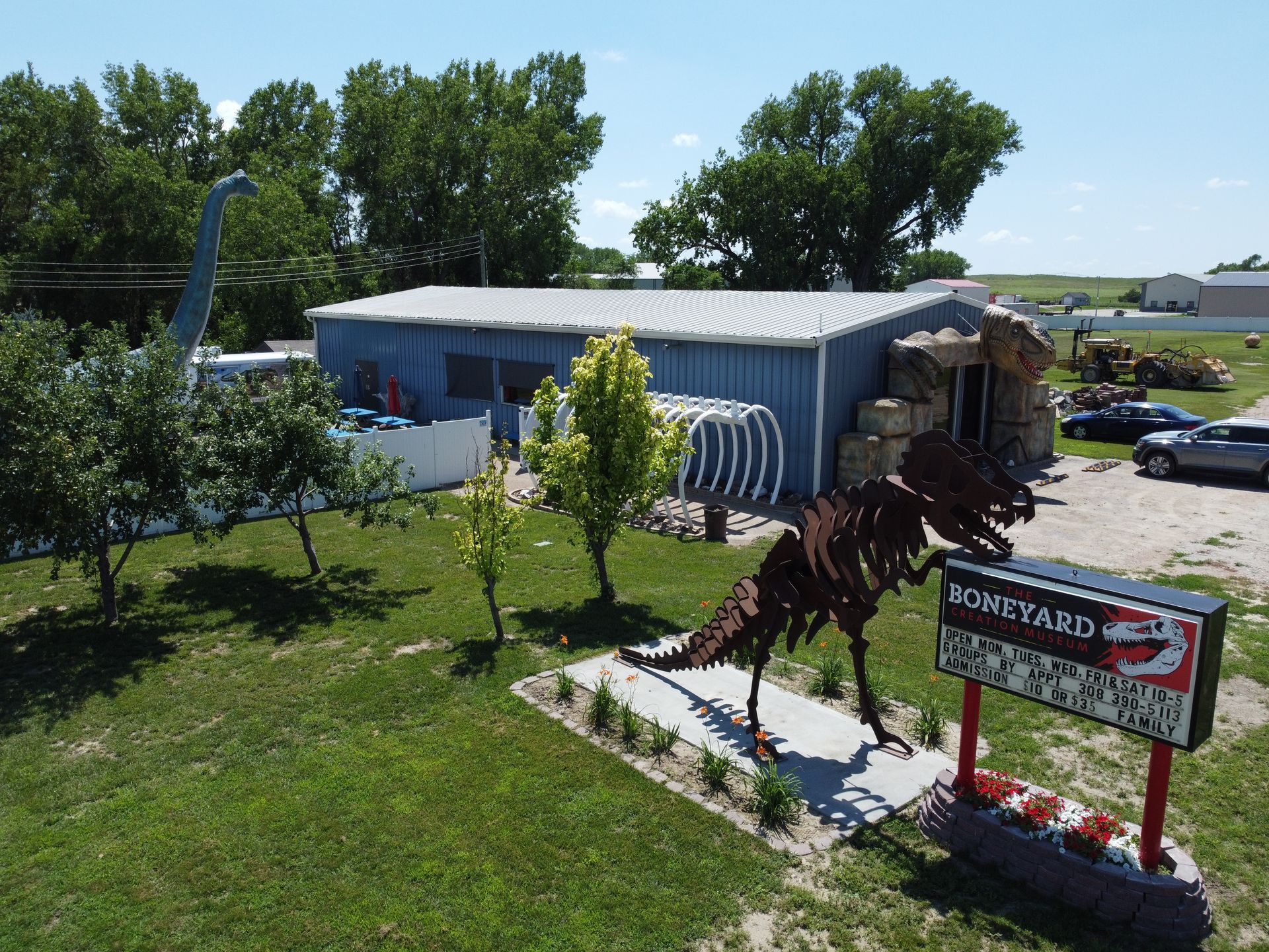An aerial view of a dinosaur statue in front of a building.