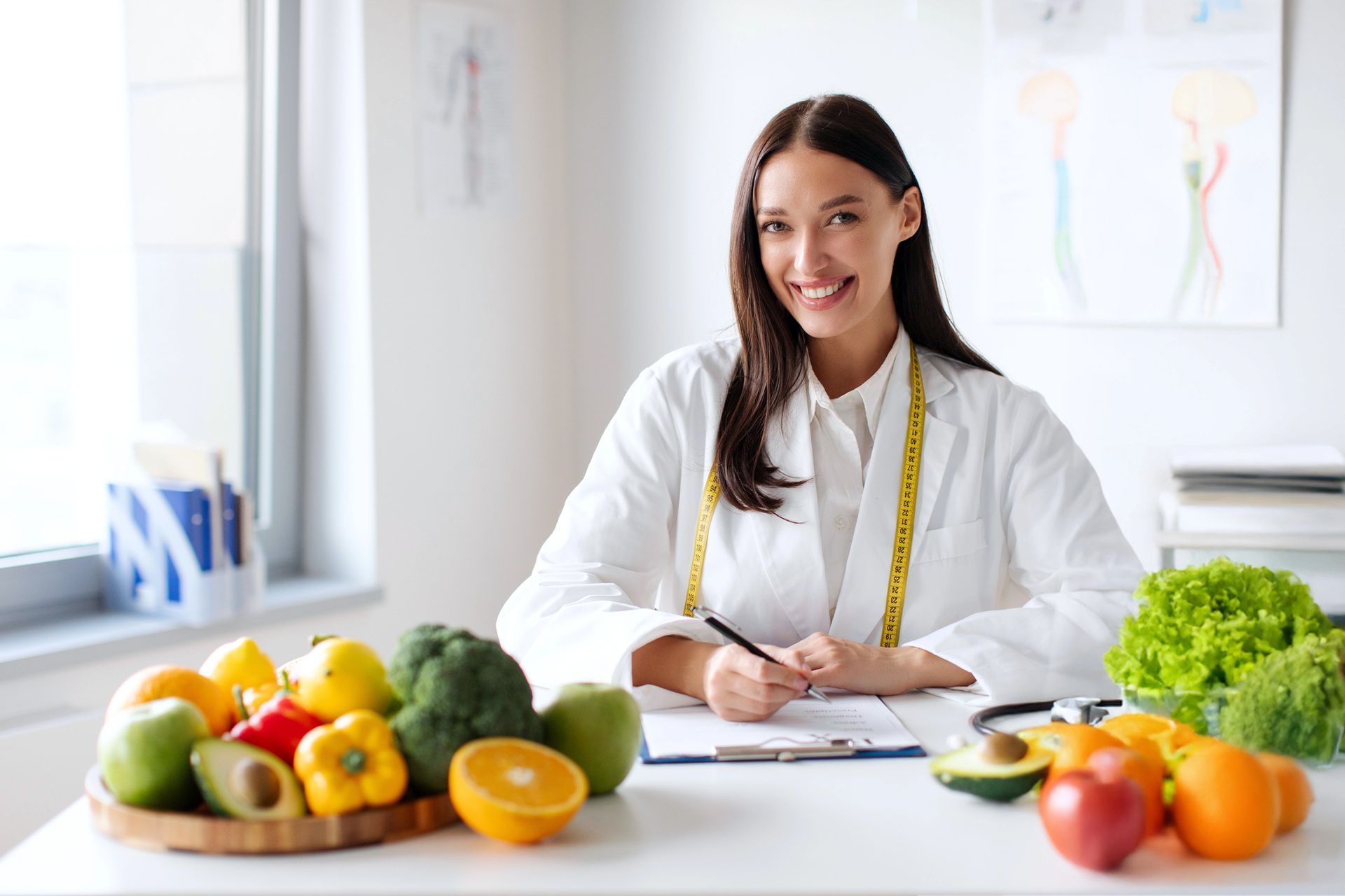 Nutritionist writing at desk with fresh fruits and vegetables in a bright office