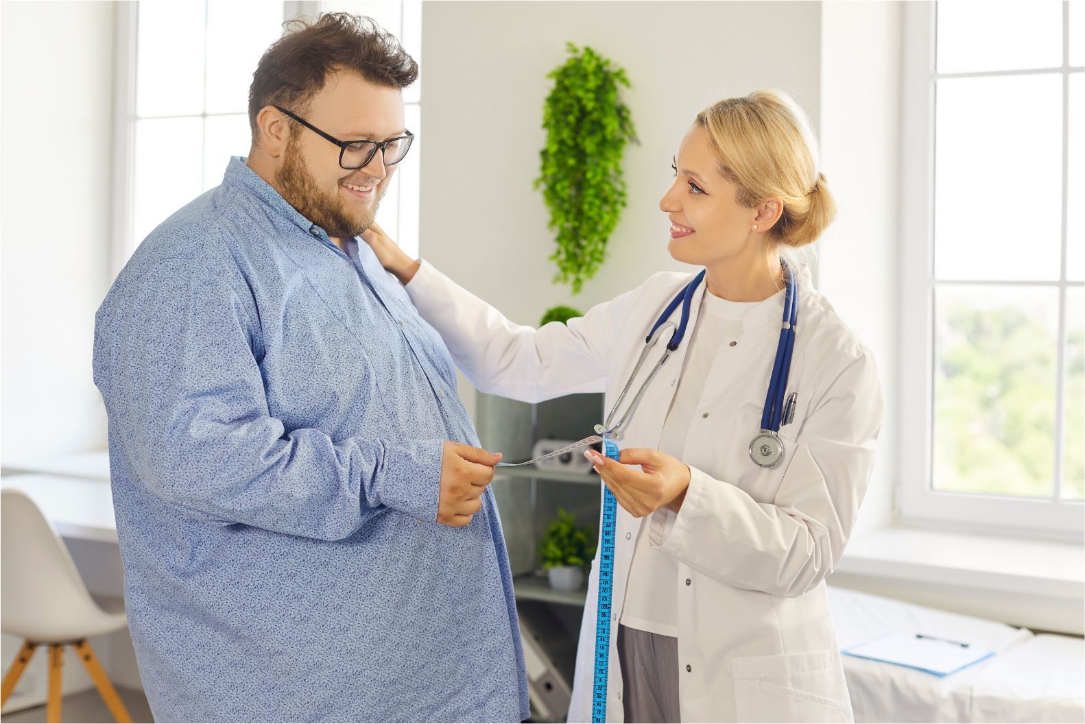 Doctor measuring a man’s waist in a bright exam room