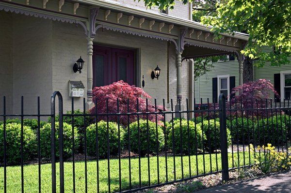 A beautiful Iron fence in the front yard of a house