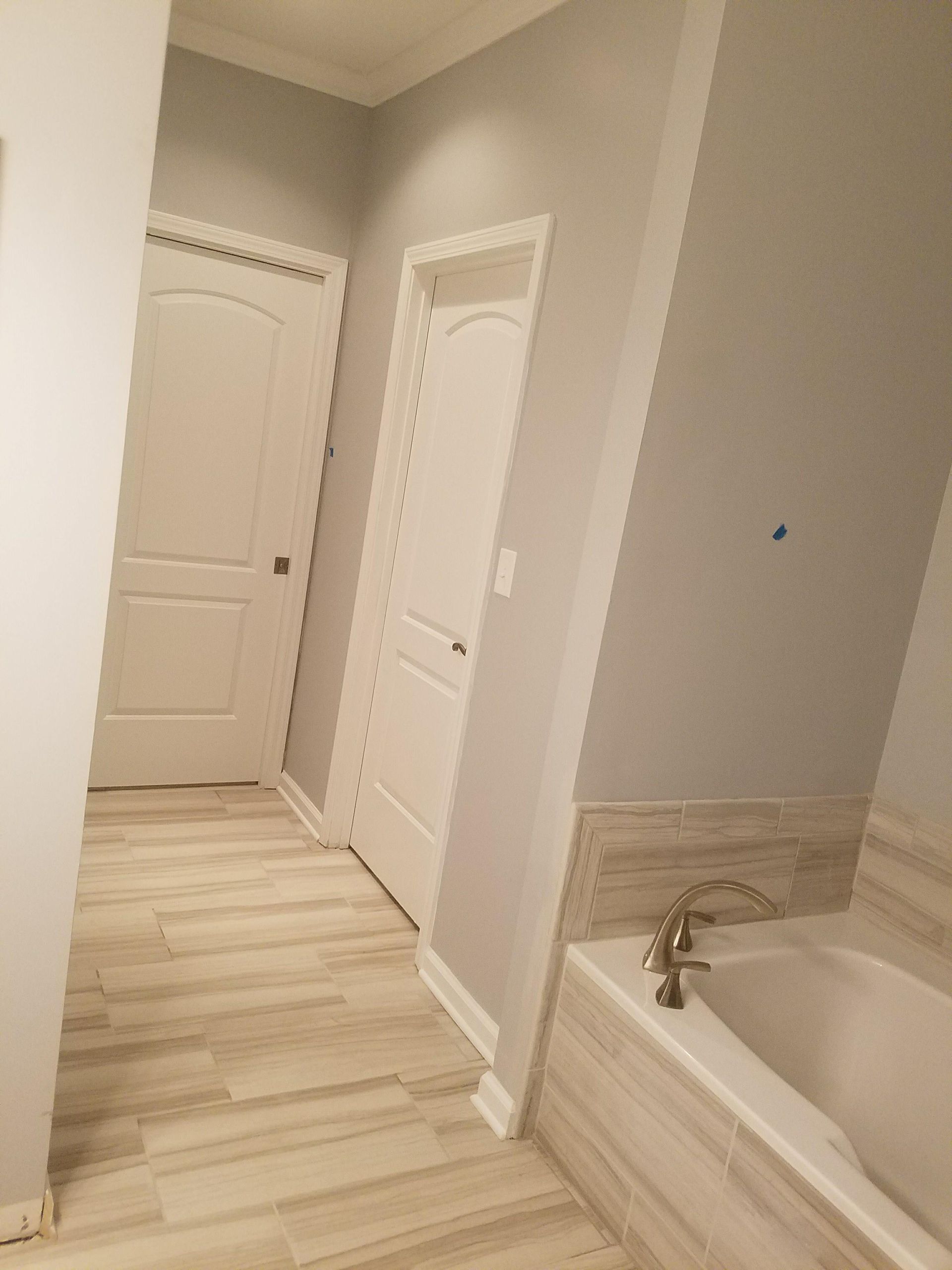 A bathroom with a bathtub and a hallway leading to it.