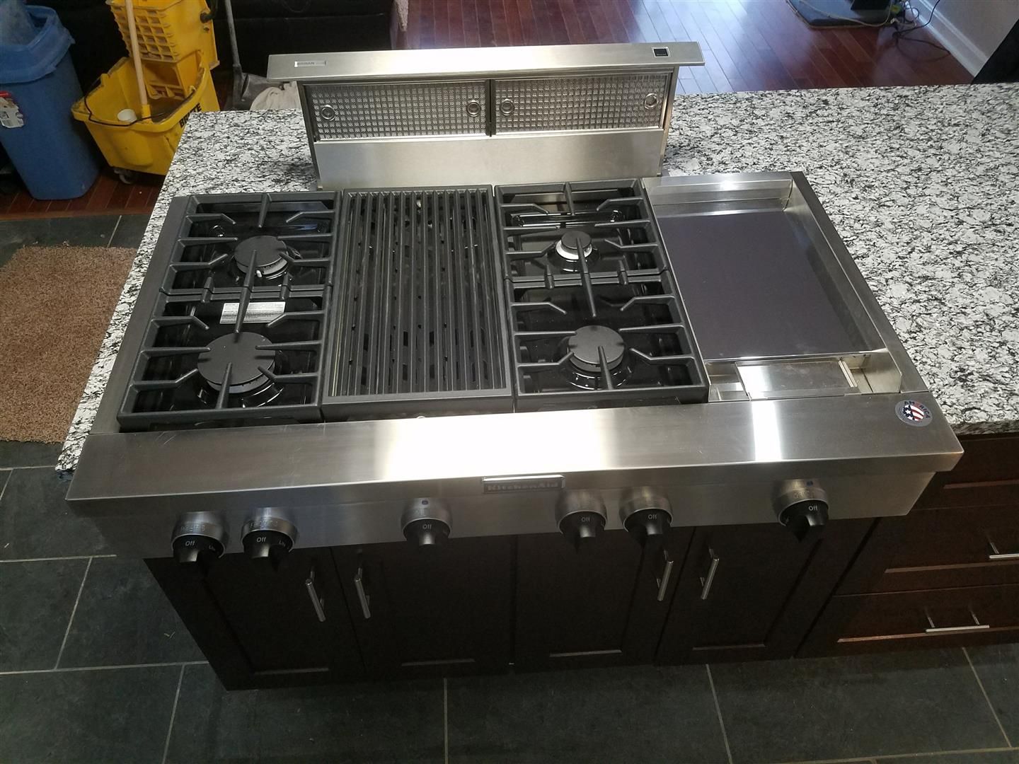 A stainless steel stove top oven is sitting on top of a granite counter top.
