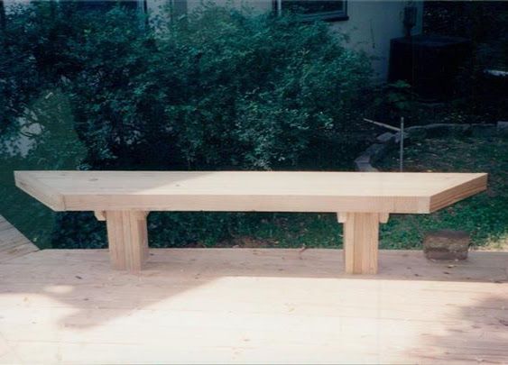 A wooden bench is sitting on top of a wooden deck.