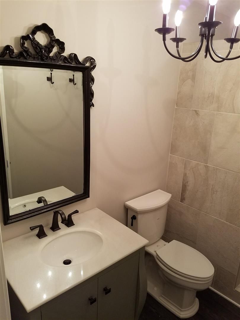 A bathroom with a toilet a sink and a mirror