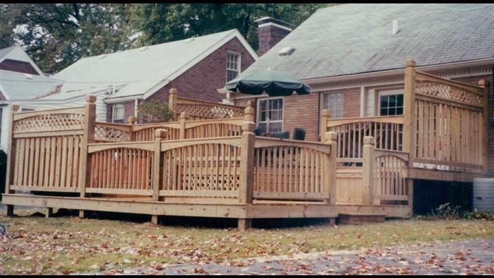 A house with a large wooden deck in front of it