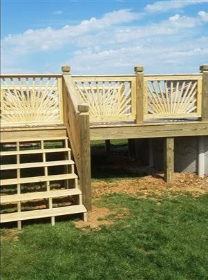 A wooden deck with stairs and a wooden railing.