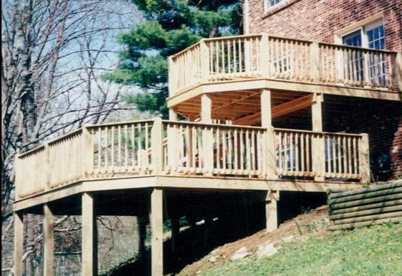 A wooden deck with a brick building in the background