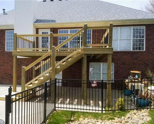 A brick house with a wooden deck and stairs