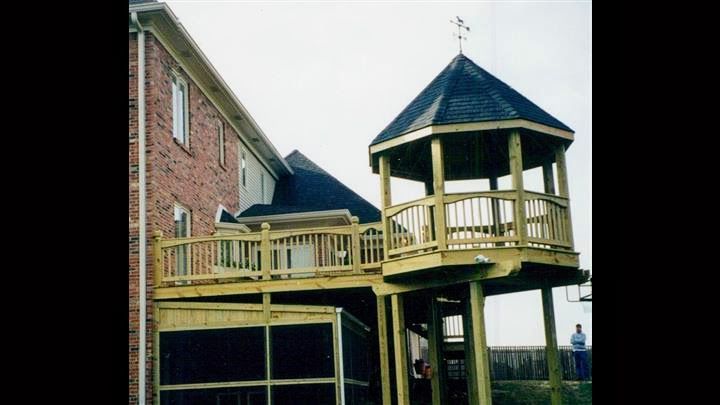 A wooden deck with a gazebo on top of it
