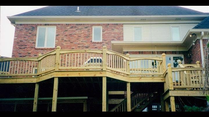 A large brick house with a wooden deck in front of it