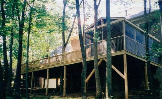 A house with a large deck surrounded by trees