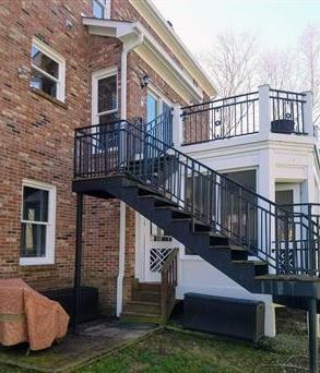 A brick house with a balcony and stairs leading up to it.