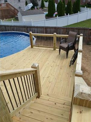 A wooden deck with stairs leading to a swimming pool.