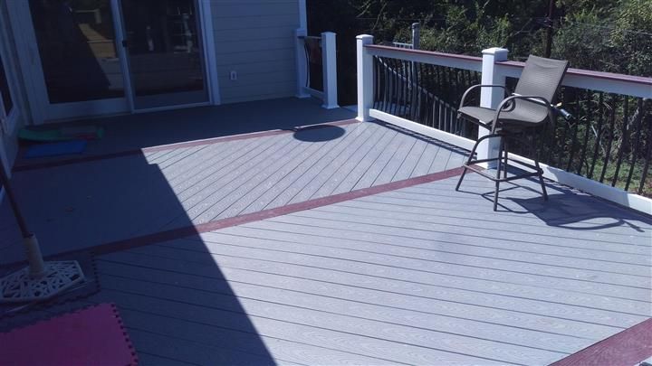 A deck with a chair on it and a railing.