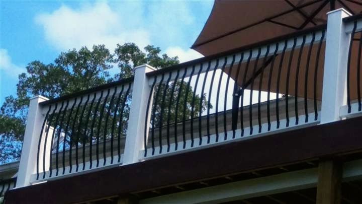 A deck with a railing and an umbrella on it