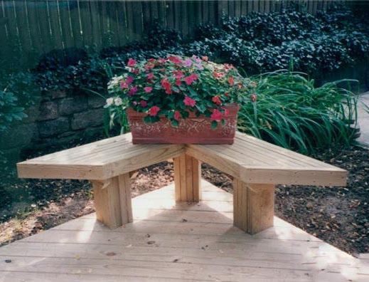 A wooden bench with a planter of flowers on it