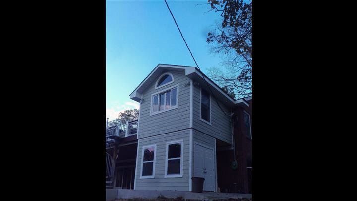 A small white house with a blue sky in the background.