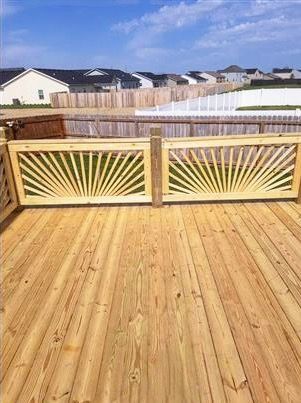 A wooden deck with a sunburst design on the railing.