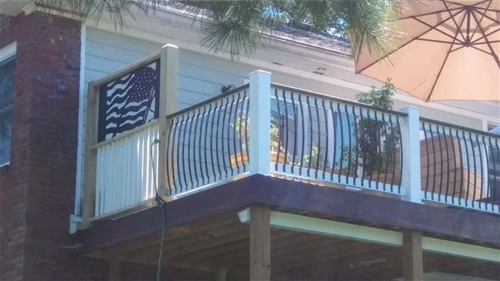 A balcony with a railing and an umbrella on a house.
