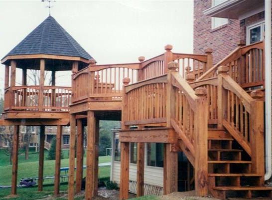 A wooden deck with stairs and a gazebo on top of it