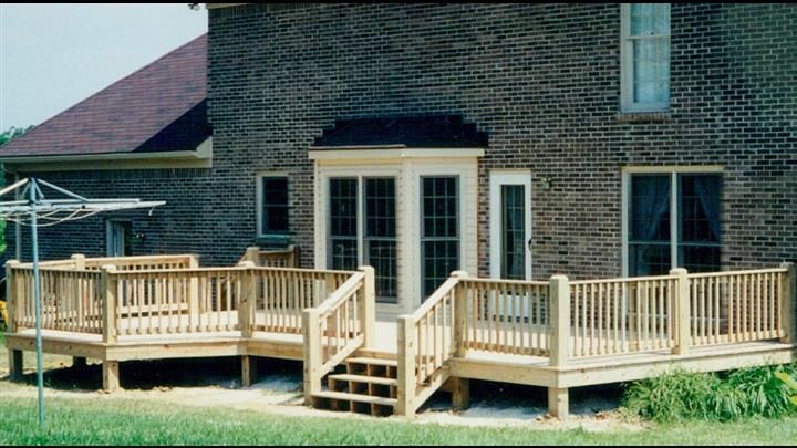 A brick house with a wooden deck in front of it