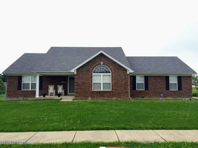A brick house with a gray roof and black shutters