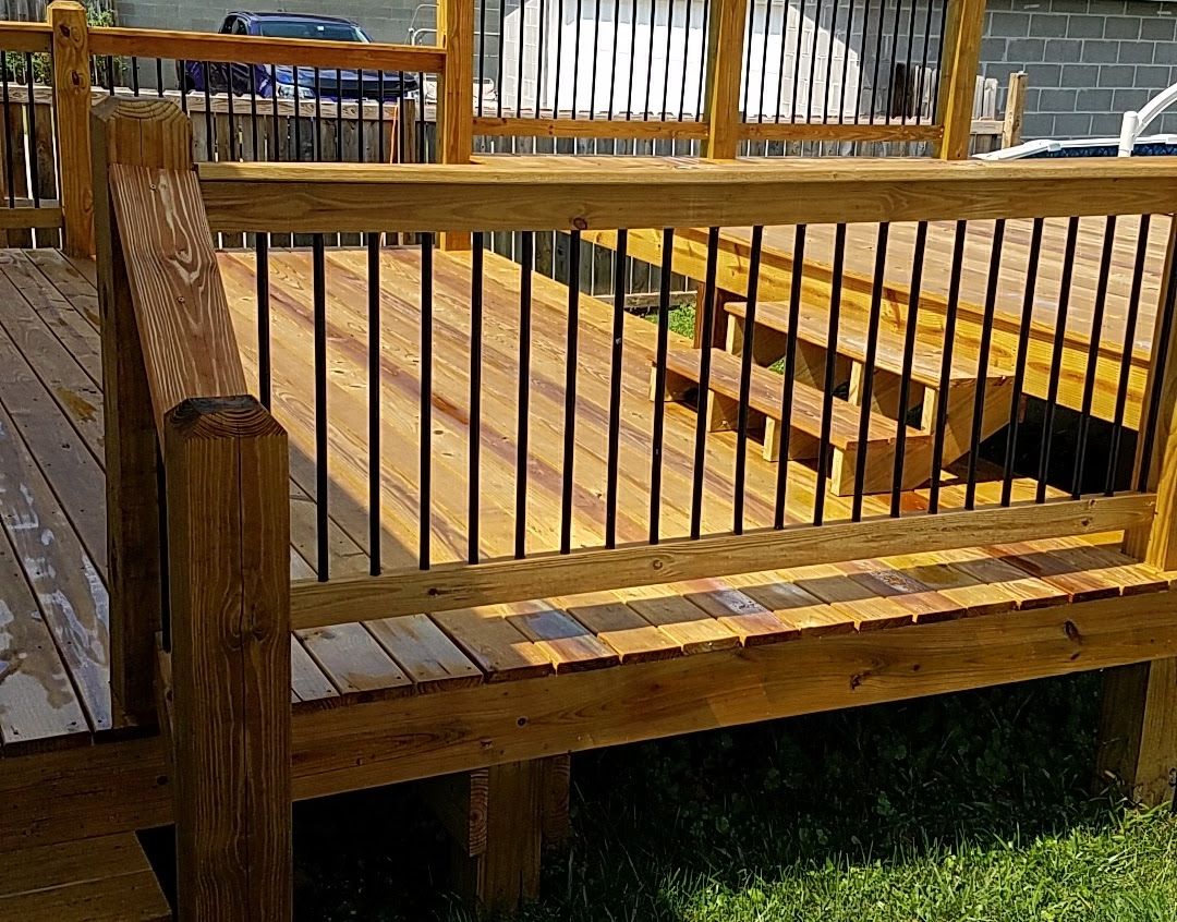 A wooden bench is sitting on top of a wooden deck.