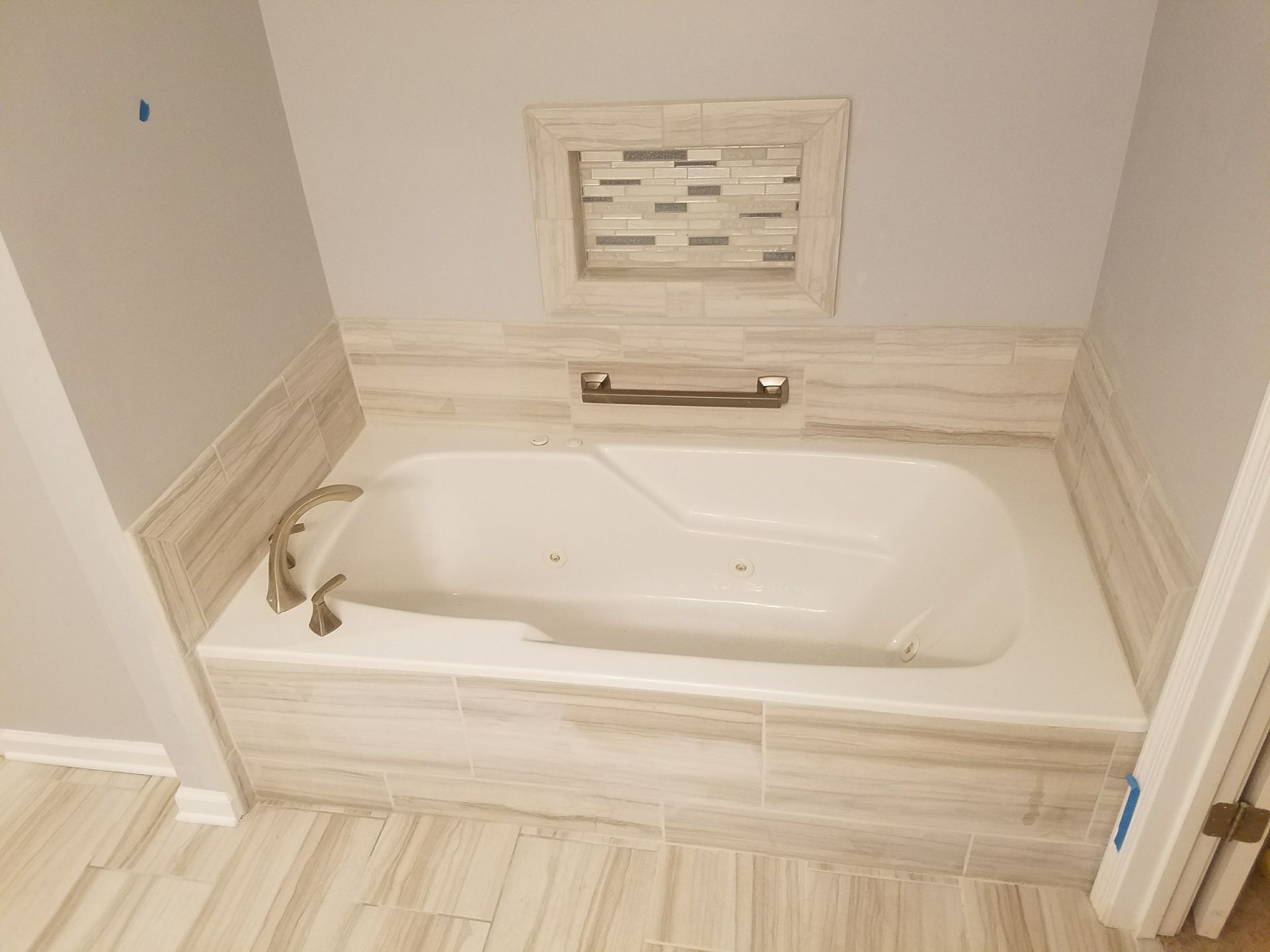 A bathtub is sitting in a bathroom next to a window.