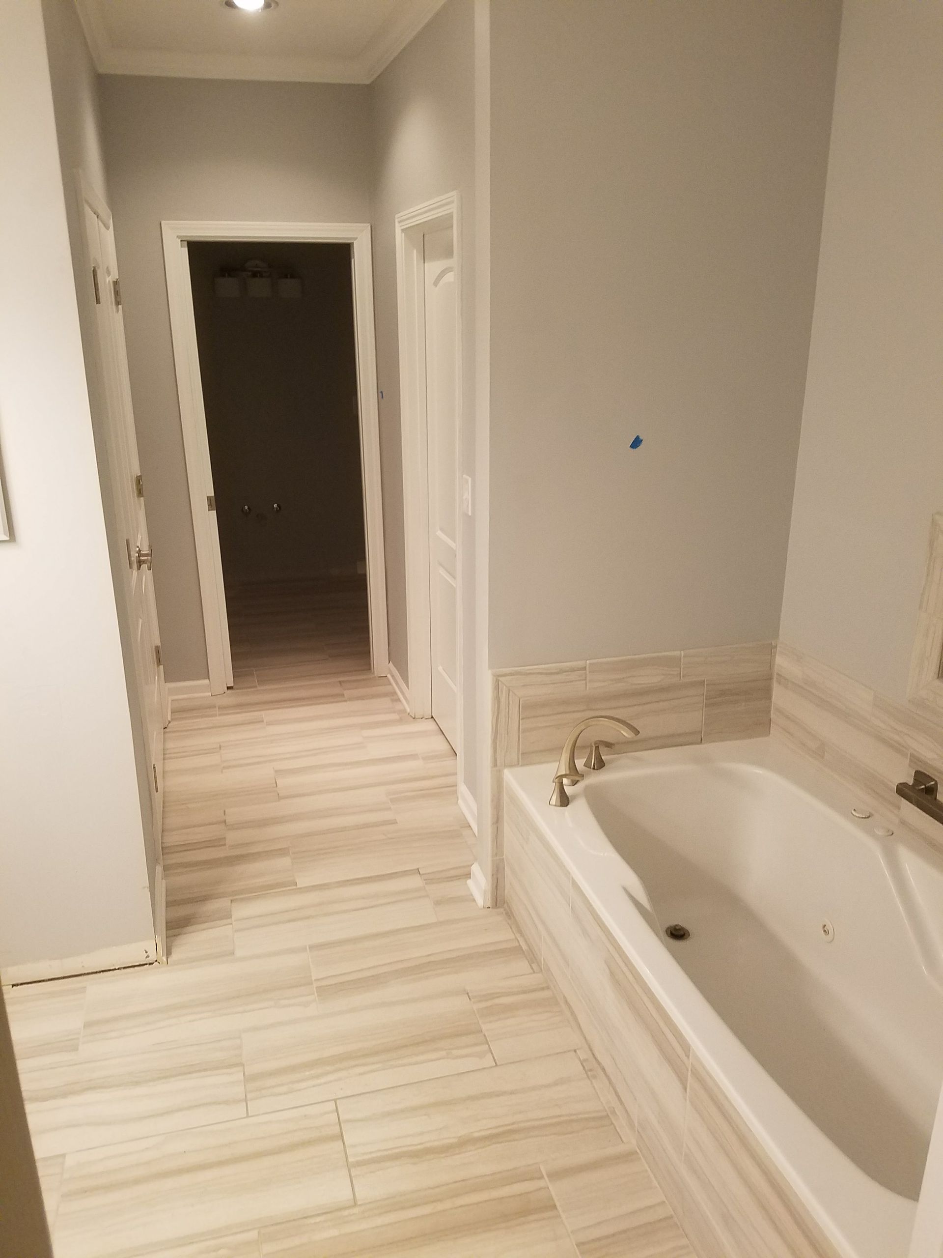 A bathroom with a bathtub and a hallway