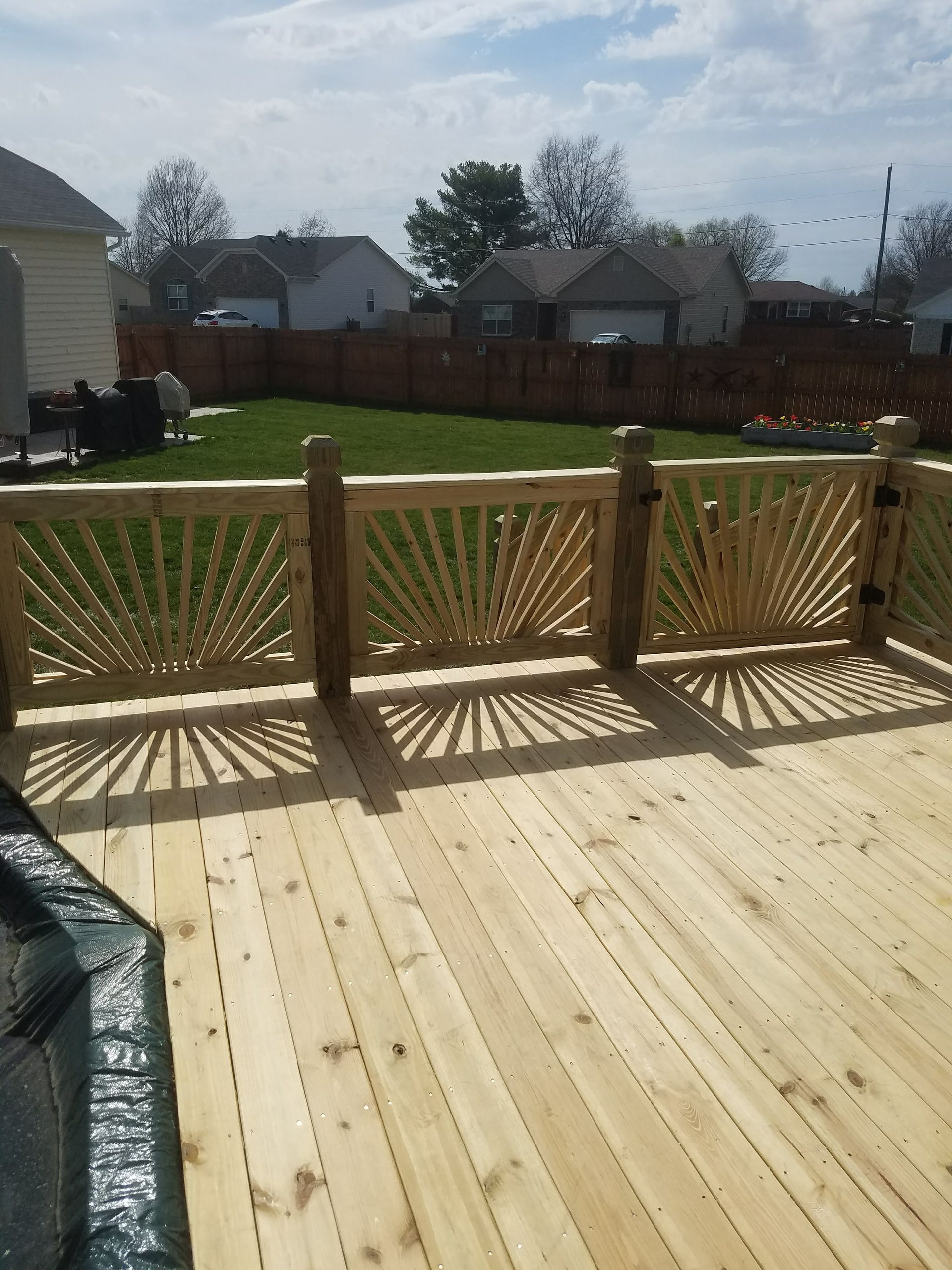 A wooden deck with a fence in the background