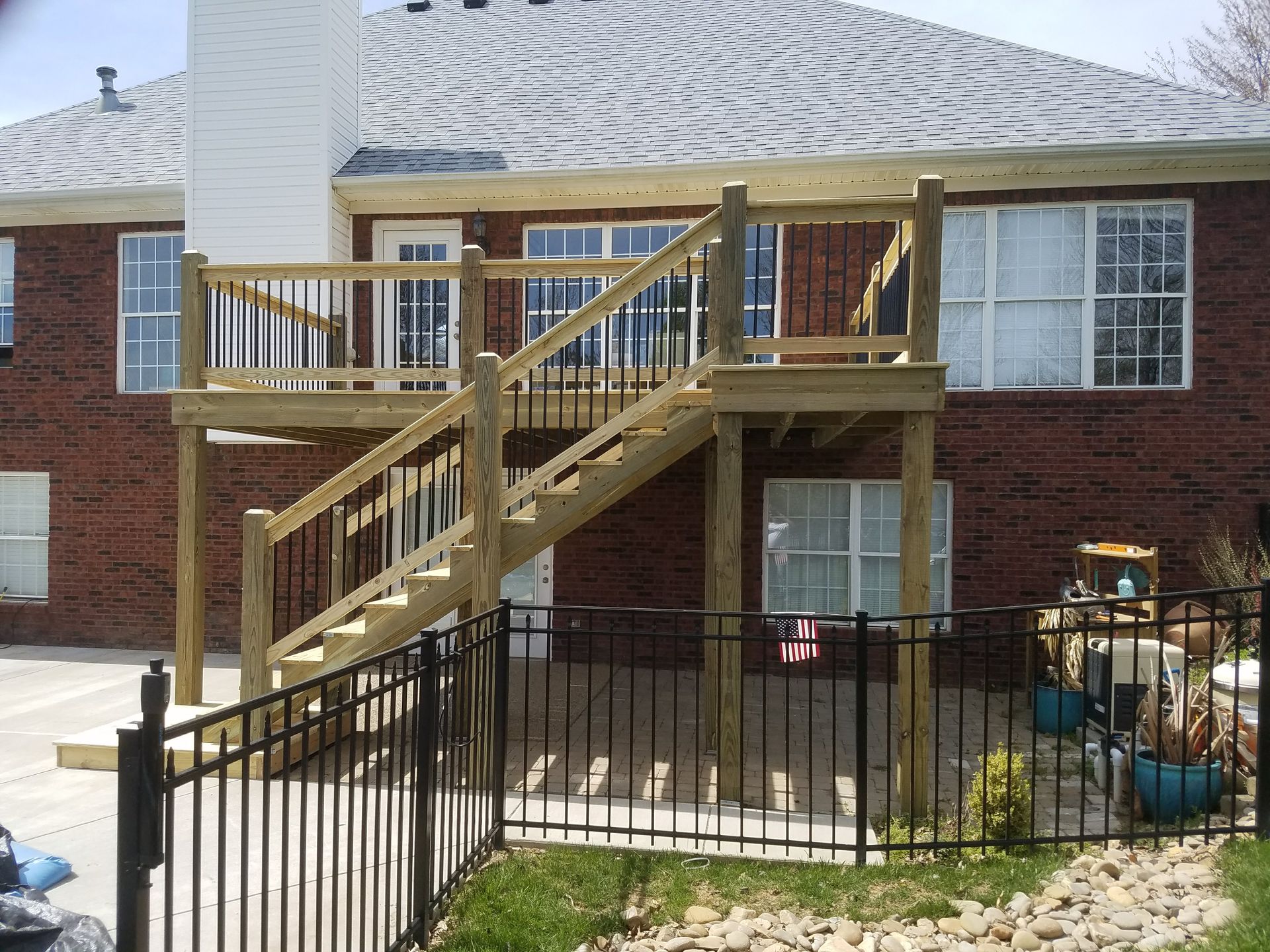 A brick house with a wooden deck and stairs