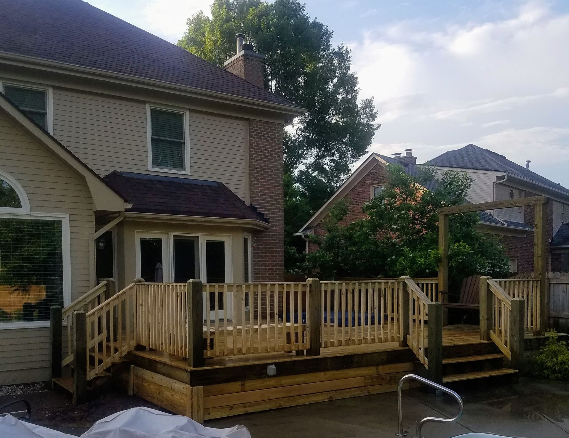 A house with a large wooden deck in front of it