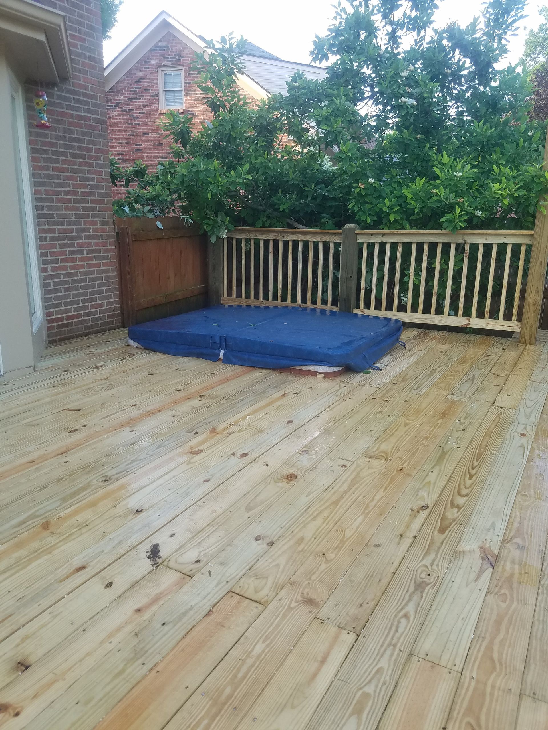 A wooden deck with a blue mattress on it.