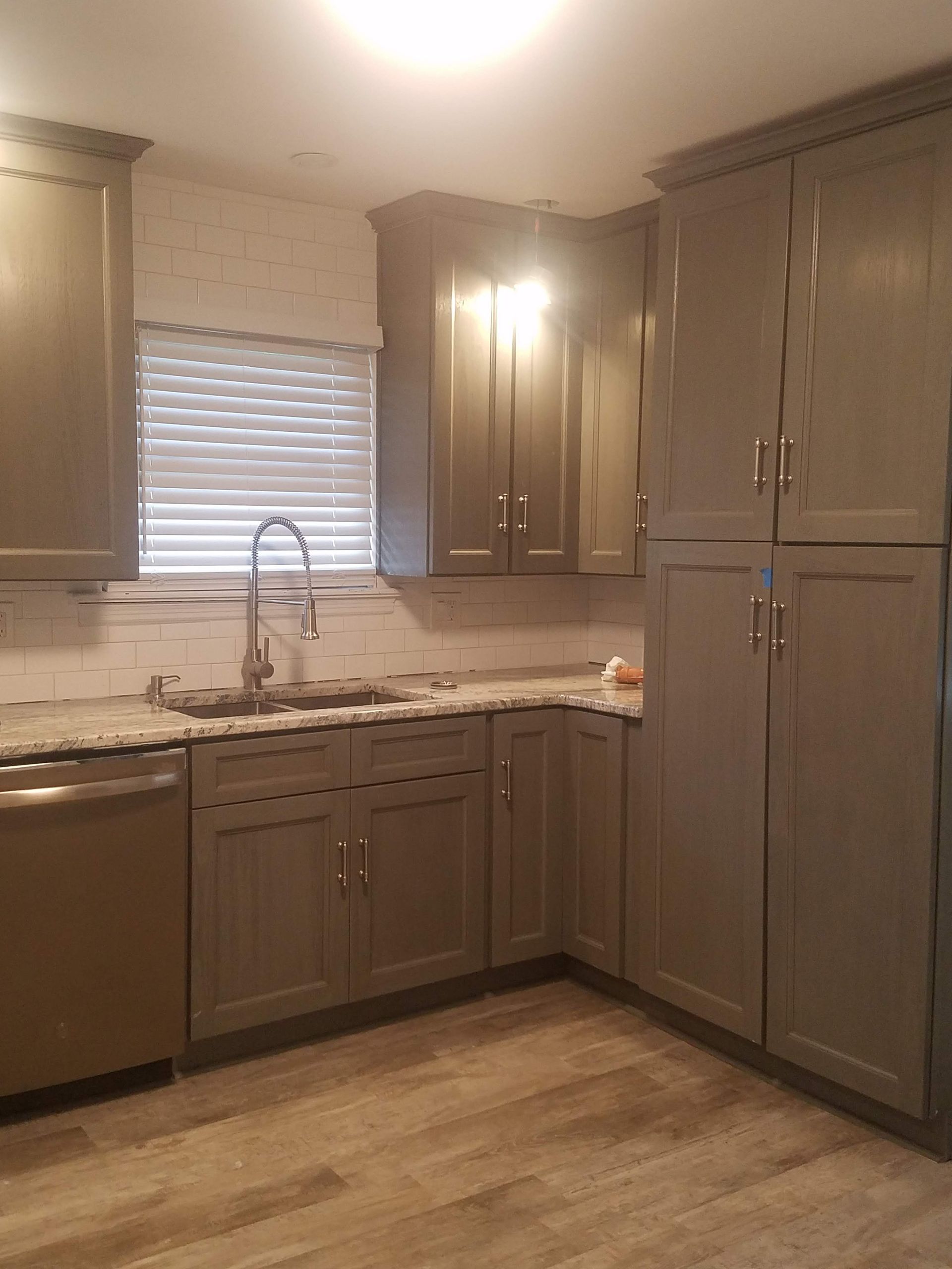 A kitchen with gray cabinets and granite counter tops