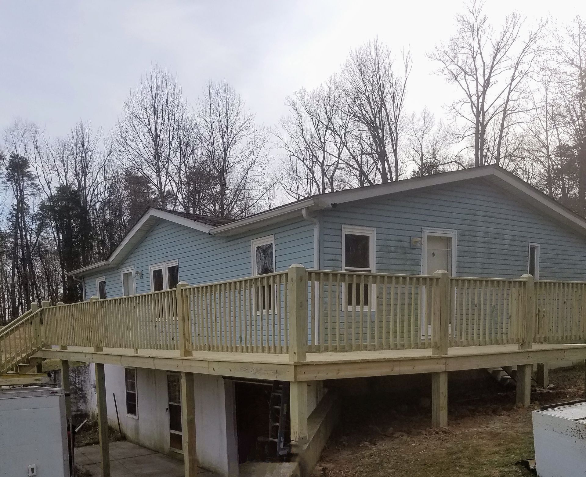 A house with a large wooden deck in front of it