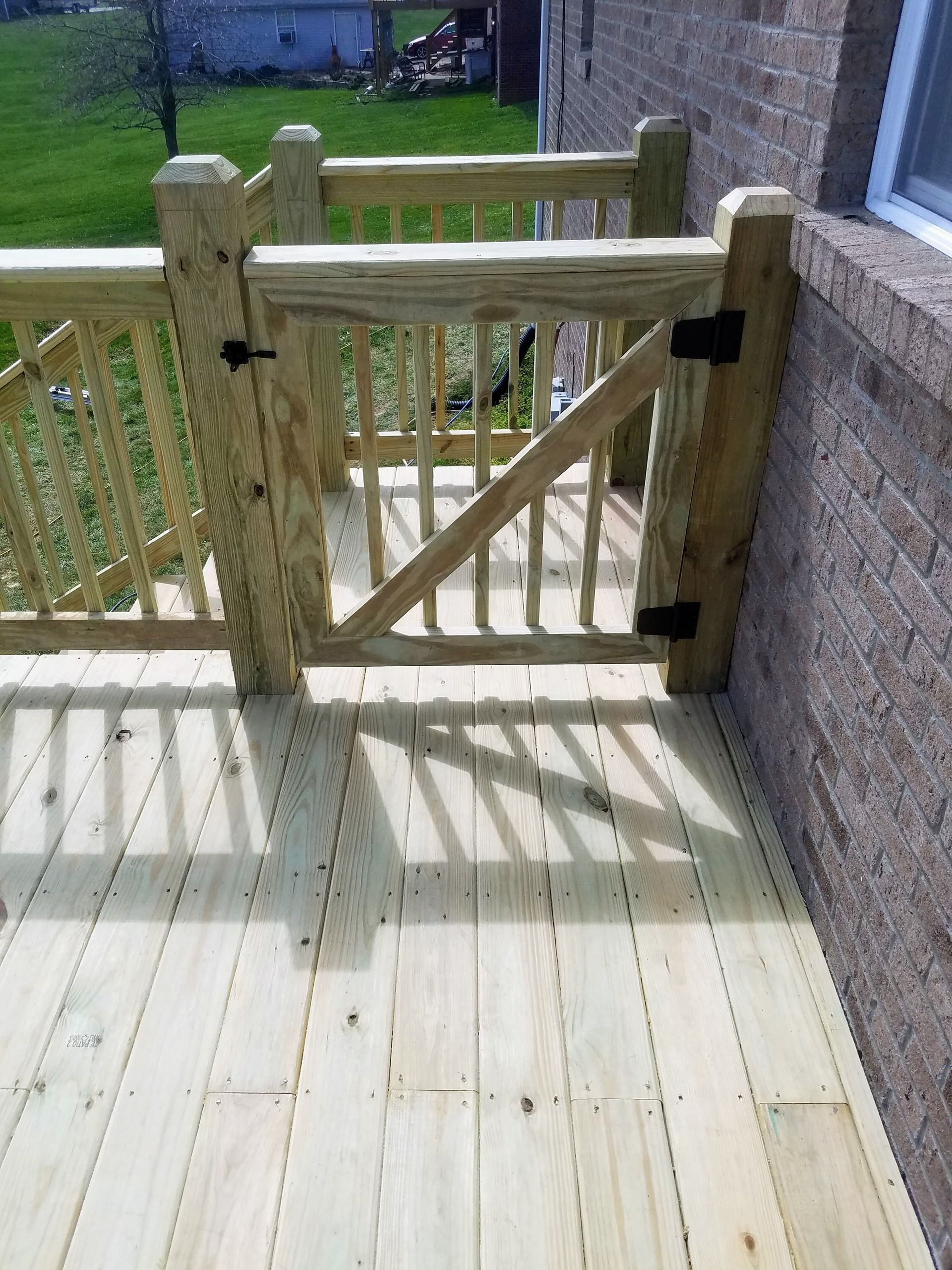 A wooden deck with a wooden gate and railing