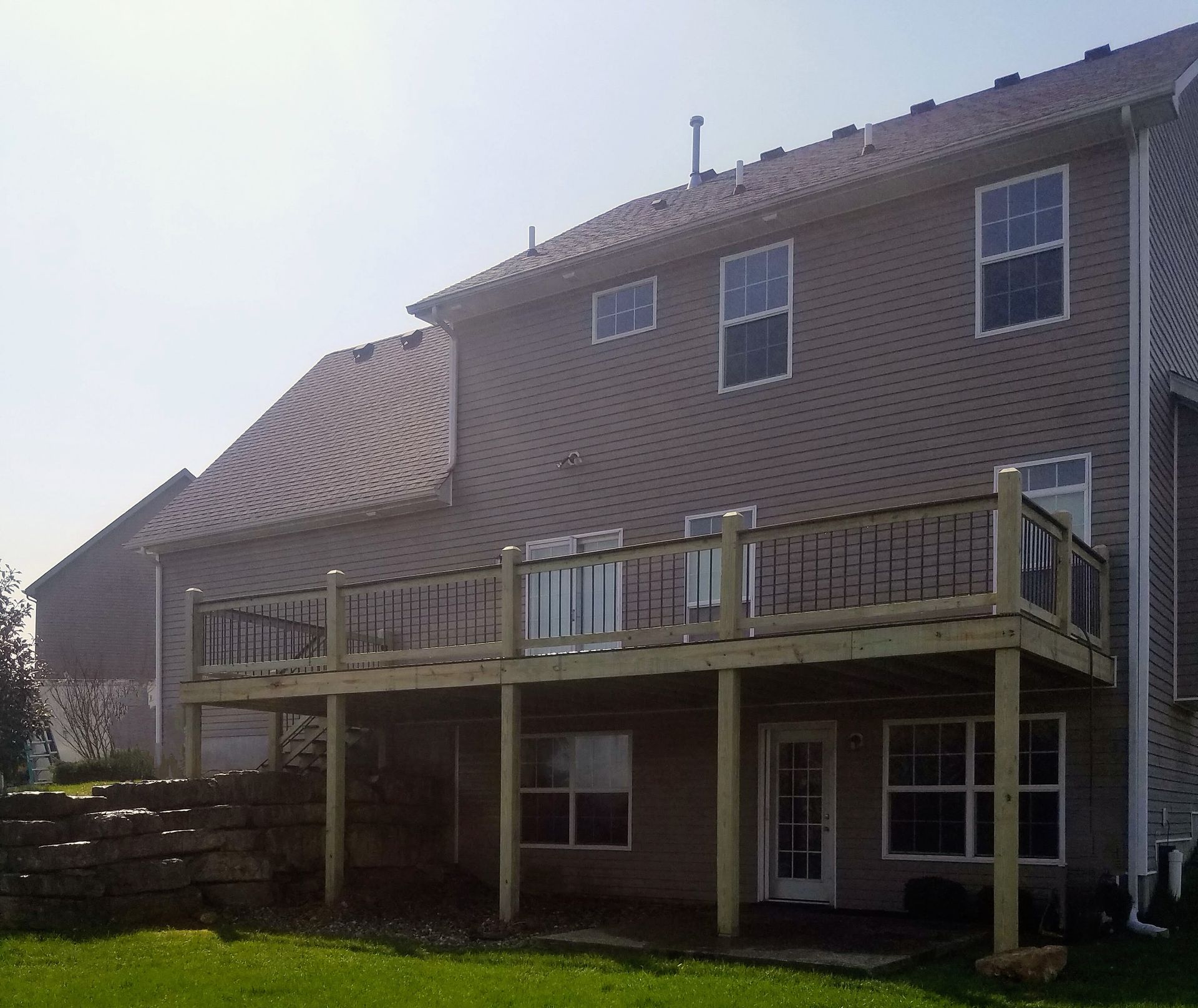 A large house with a wooden deck in front of it