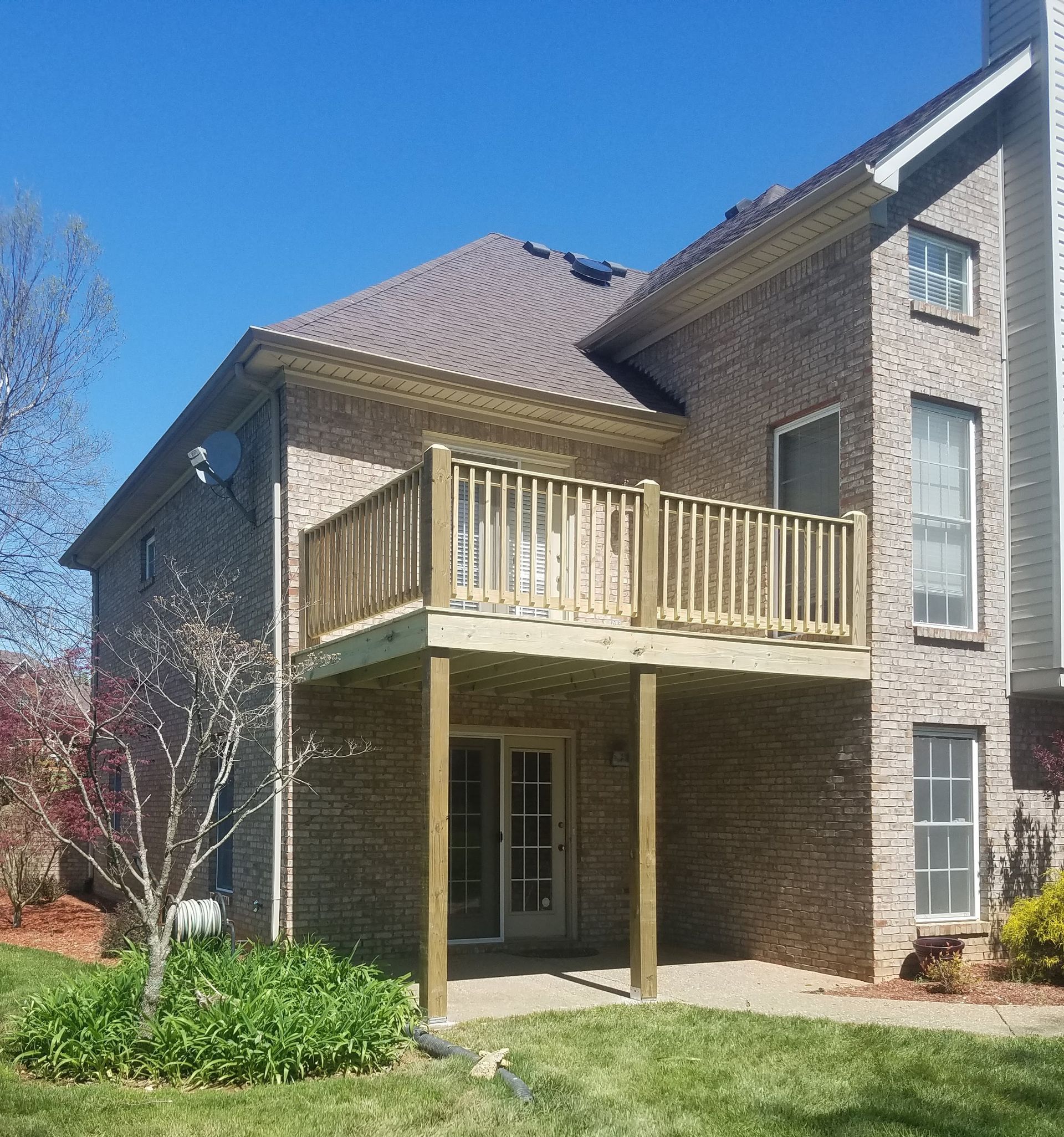 A large brick house with a wooden deck