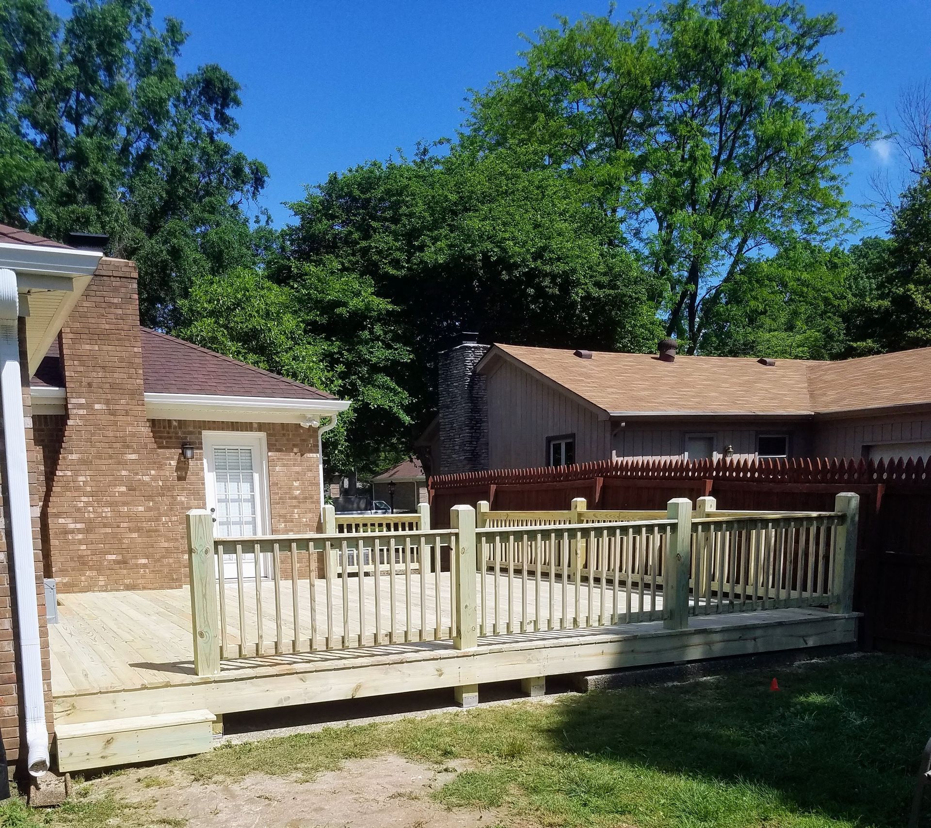 A brick house with a wooden deck in front of it