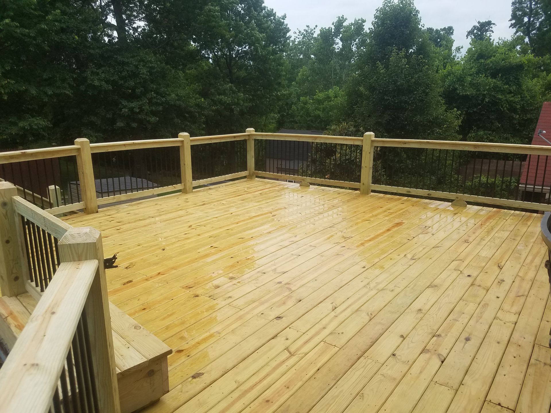 A large wooden deck with trees in the background